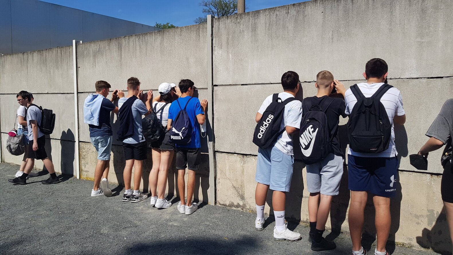 Schüler*innen vor Resten der Berliner Mauer.