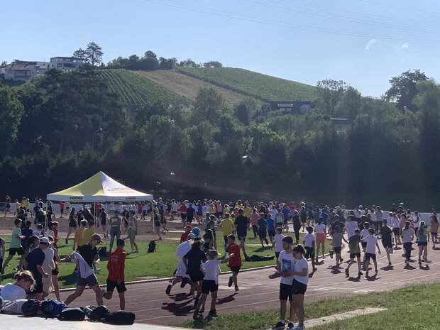 Foto von vielen Schüler*innen, die sich auf dem Sportplatz einlaufen für das Sportfest.