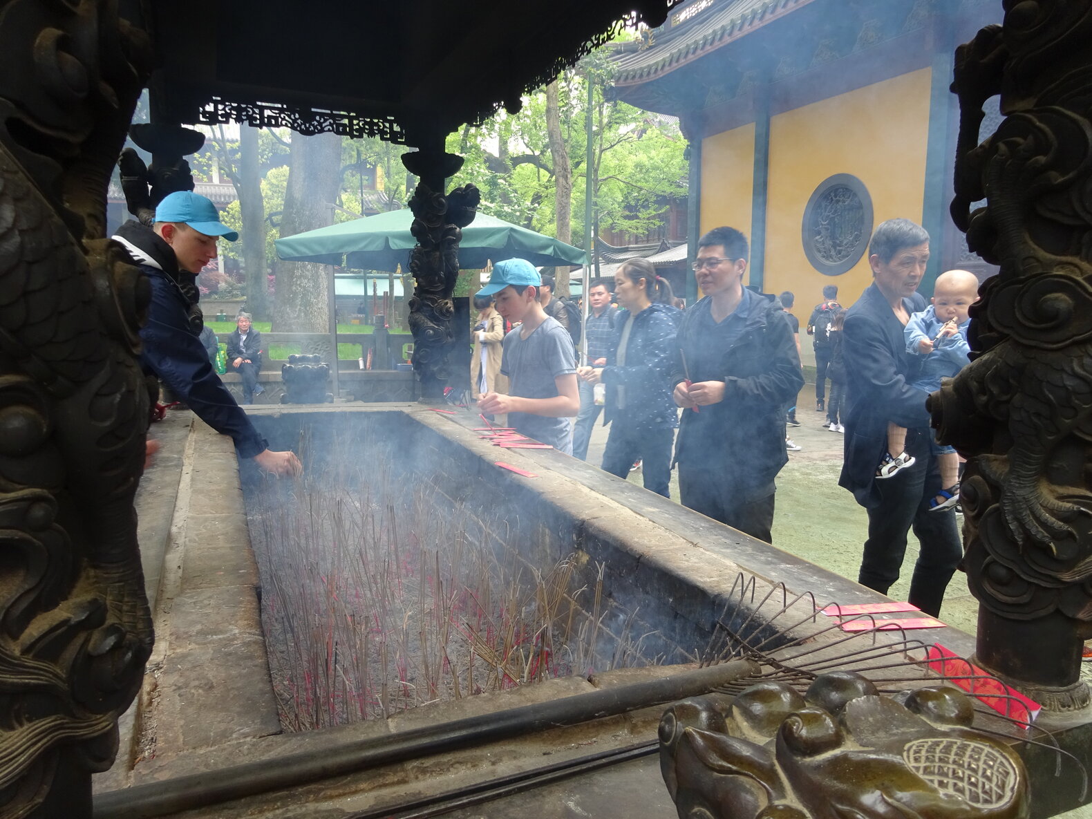 Schüler*innen, die Räucheerstäbchen in einem chinesischen Tempel anzünden.