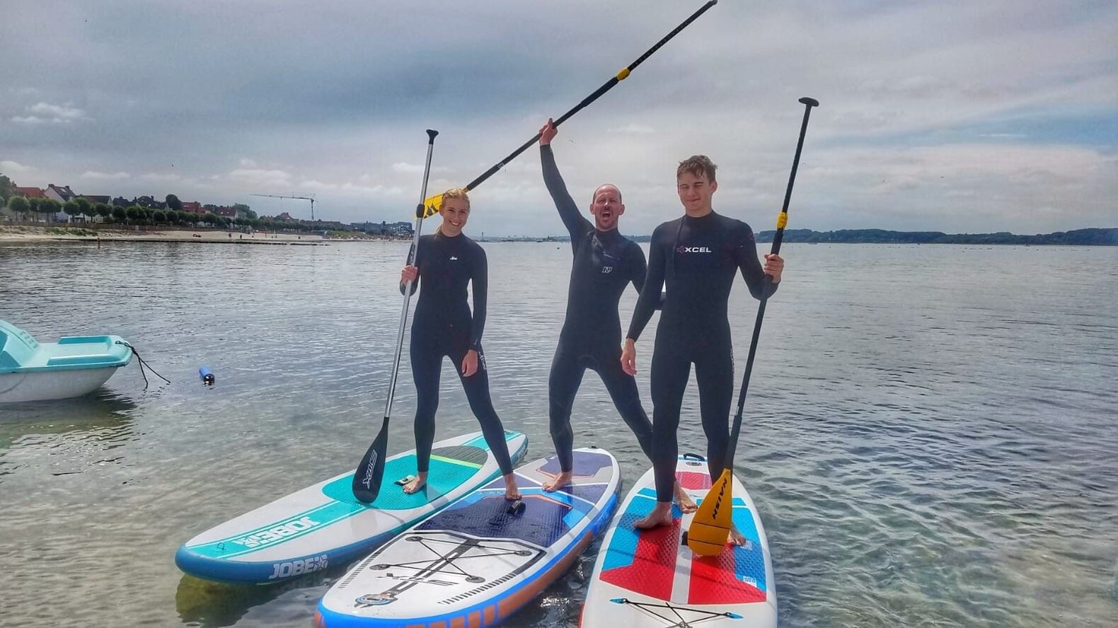 Drei Personen beim Stand Up Paddling.