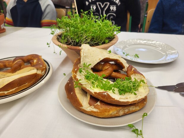 Foto eines Esstisches mit Tellern, auf denen Brezeln liegen.