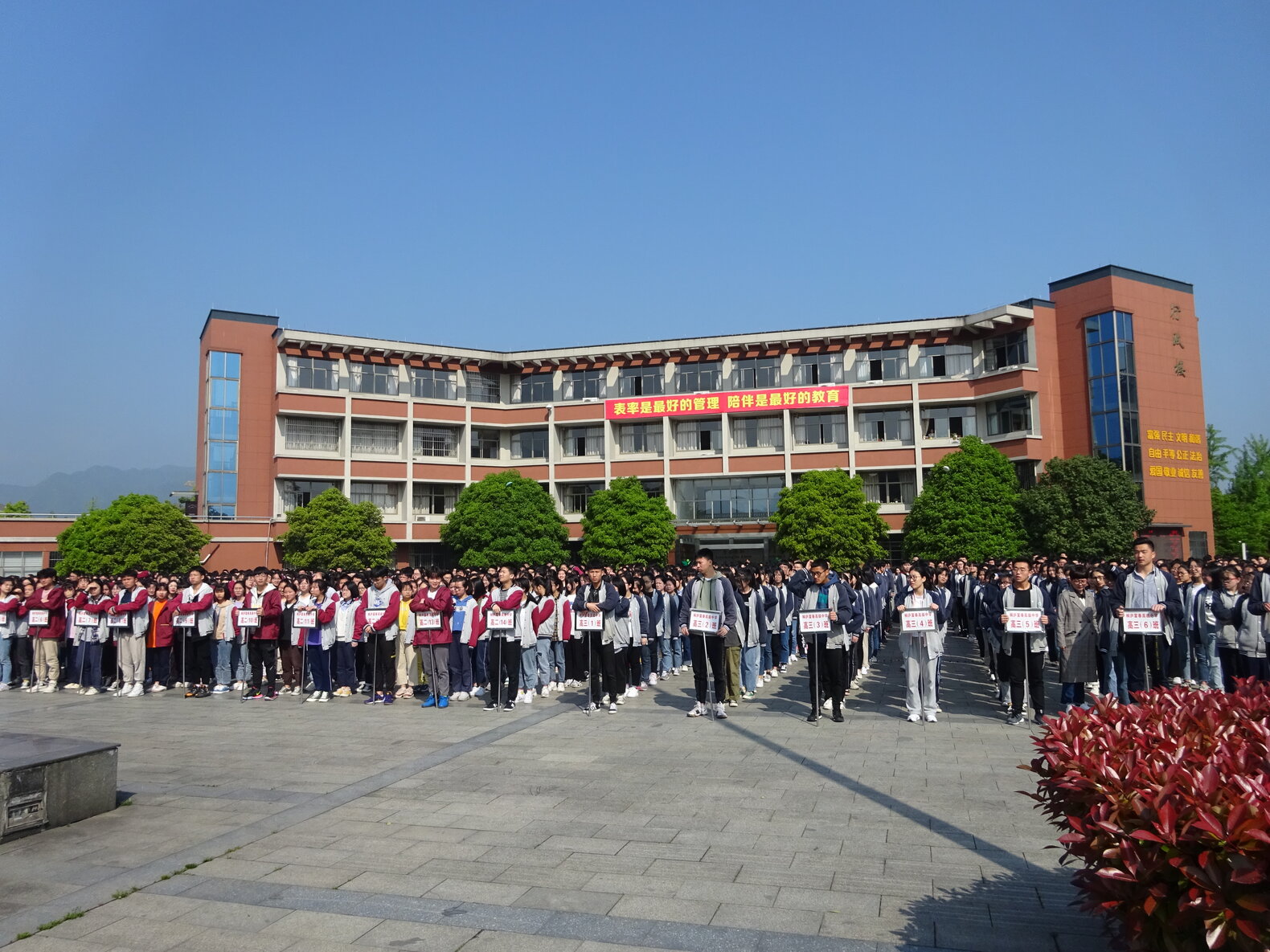 Chinesische Schüler*innen vor einem Schulgebäude.