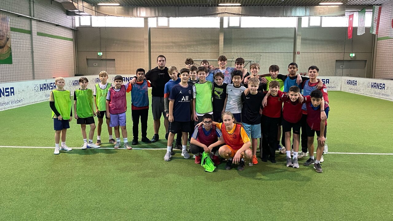 Foto einer Gruppe Jungen auf einem Indoor-Fußballplatz.