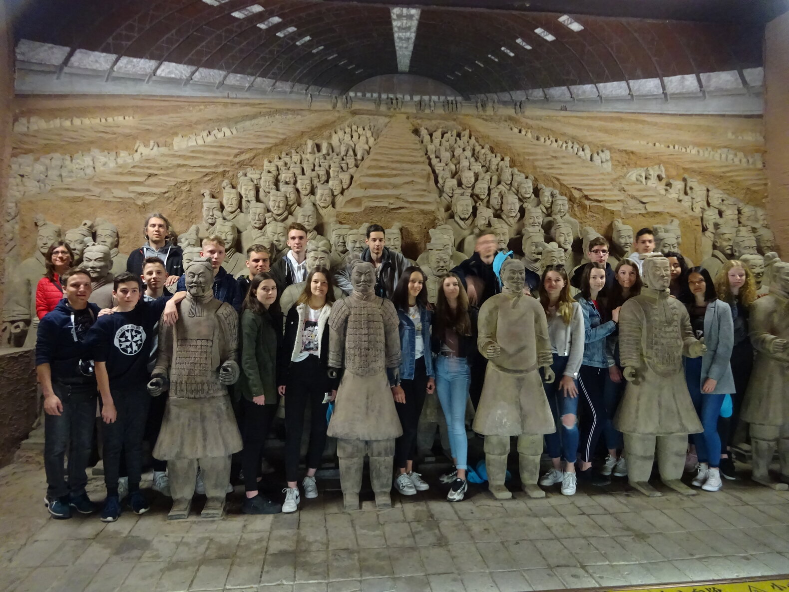 Schüler*innen, die zwischen Statuen stehen.