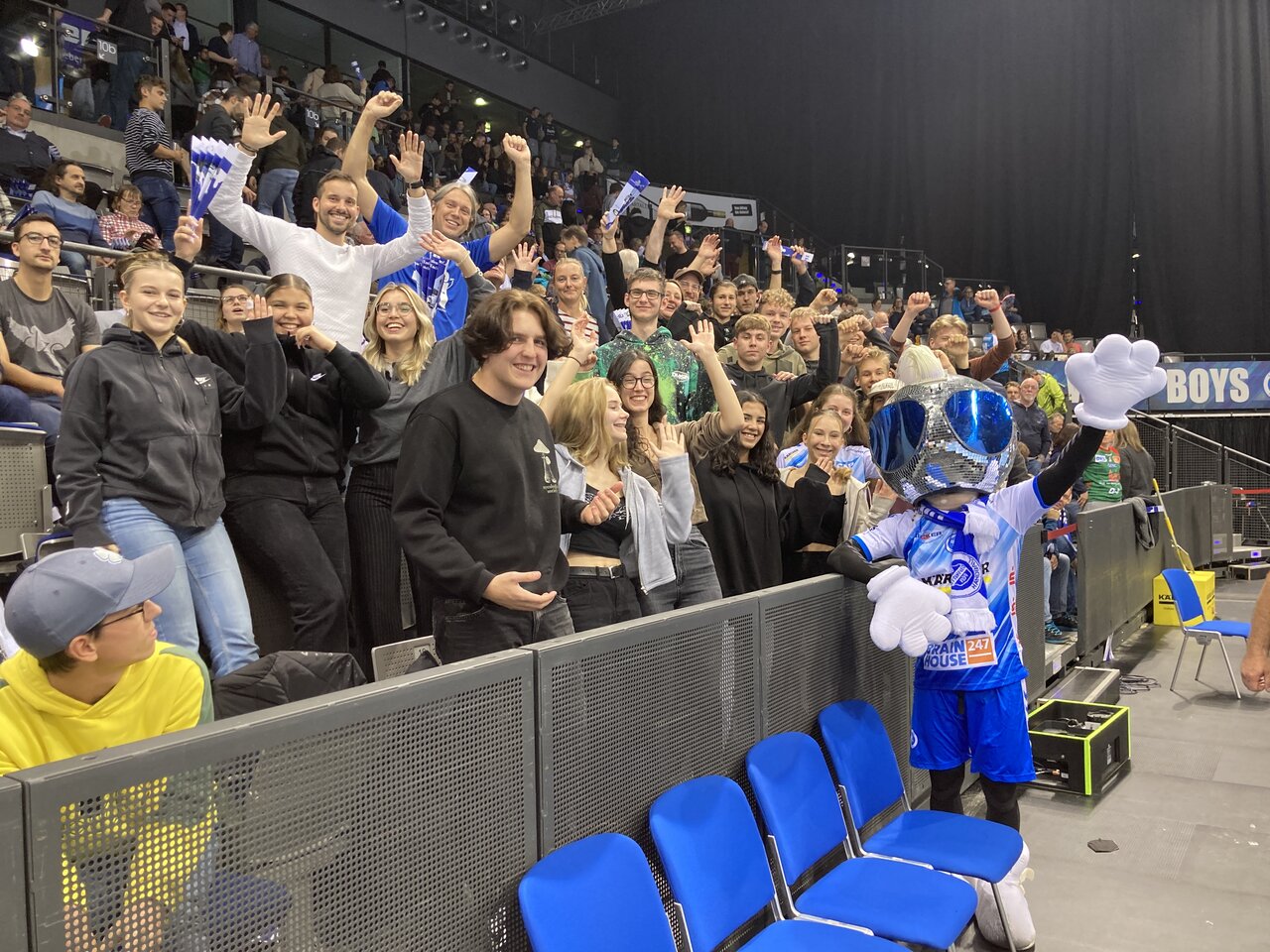 Foto eines jubelnden Publikums auf einer Tribüne in einer Halle.